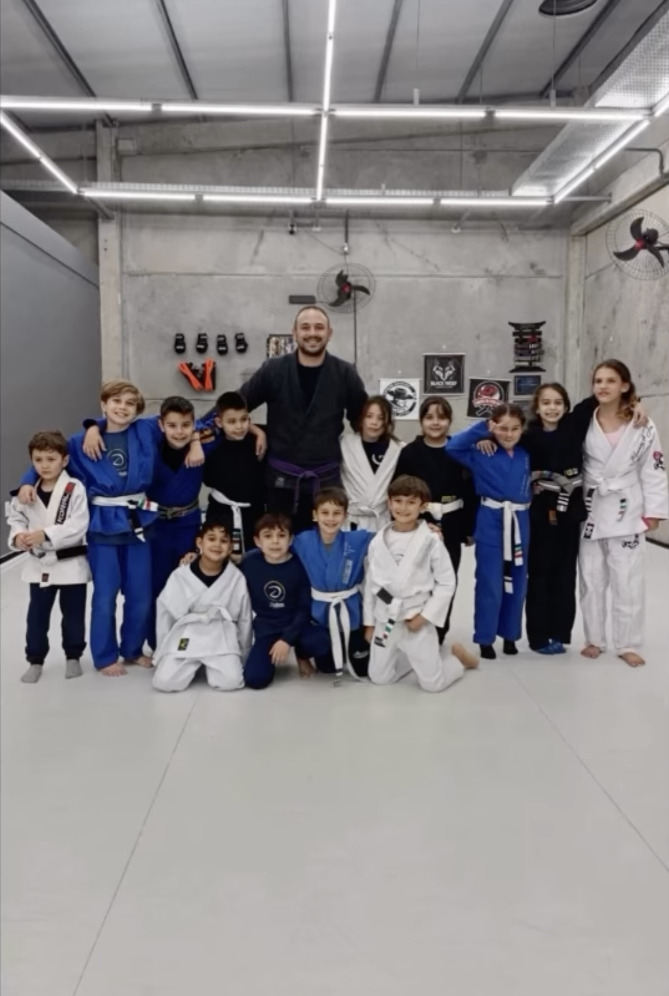 Professor faixa roxa com a turma de Jiu-Jitsu Kids da Black Wolf, em Capão da Canoa